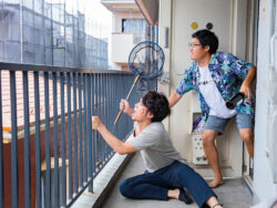 Zwei Männer auf einem Balkon - Filmszene aus Shinichiro Uedas POPRAN © 2022 ”Popran” Film Partners
